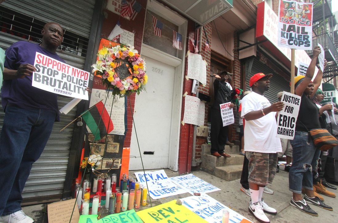 At the site of Garner’s killing, a man holds a sign supporting the NYPD while condemning some of its actions; a repeated refrain during the rally was “This is not a march against cops.”